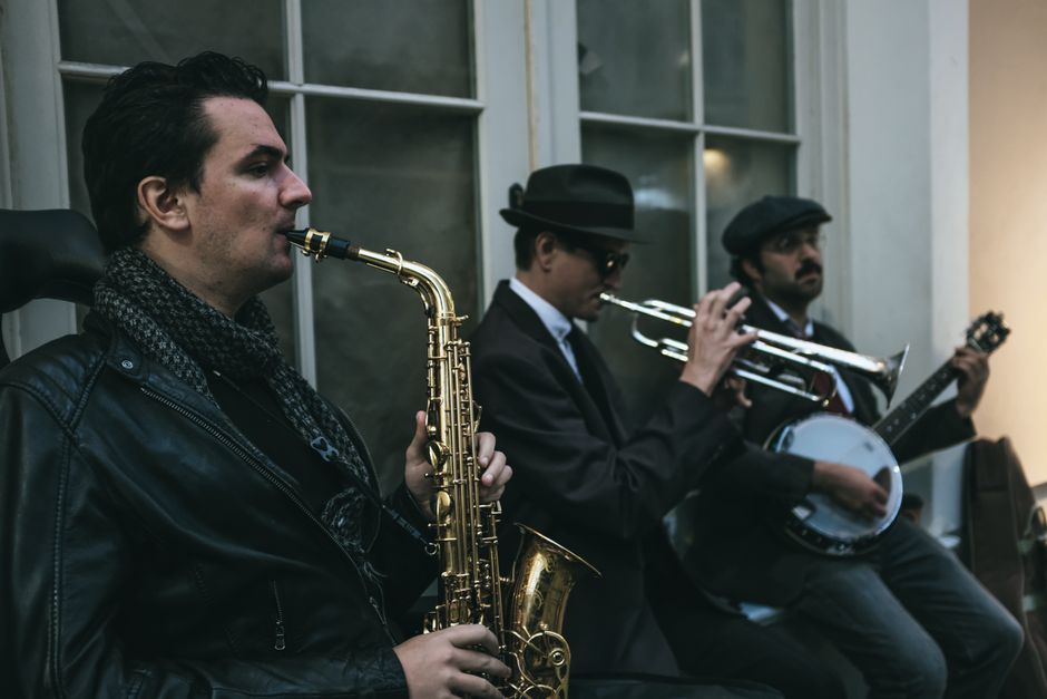 Street musicians playing saxophone, trumpet, and banjo in a classic jazz ensemble.